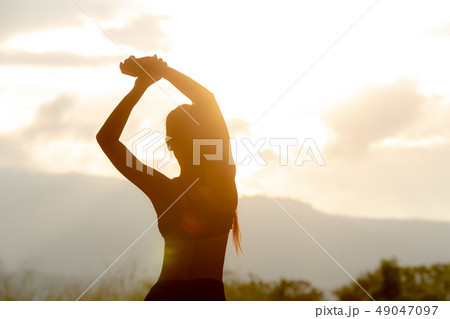 Asian woman stretching in the mountains in the eve 49047097