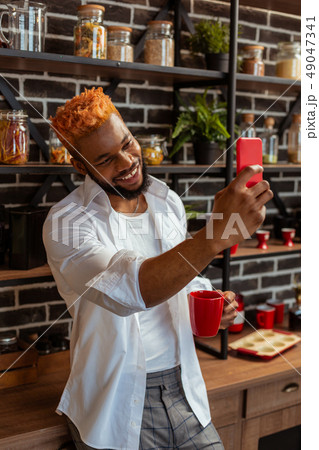 Delighted positive man taking selfies on his phone 49047341