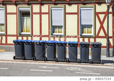 Garbage bins on the street outside an old house 49047534