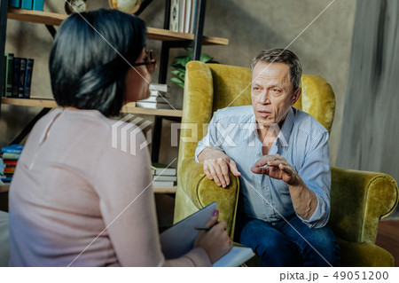 Communicative old man in light shirt talking to specialist Communicative old man in light shirt talking to specialist 49051200