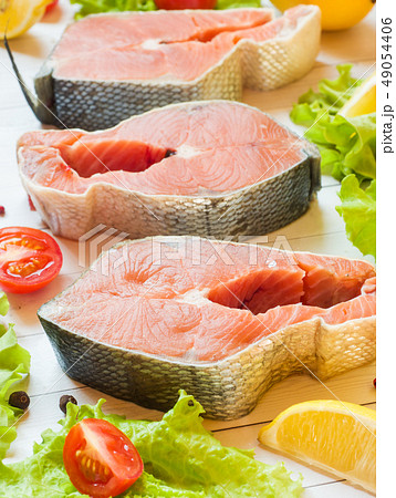 Raw red fish steak with lemon and spices on light  49054406