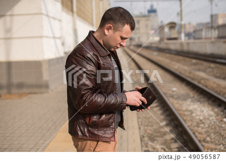A man holds a purse in his hand and counts money A man holds a purse in his hand and counts money 49056587