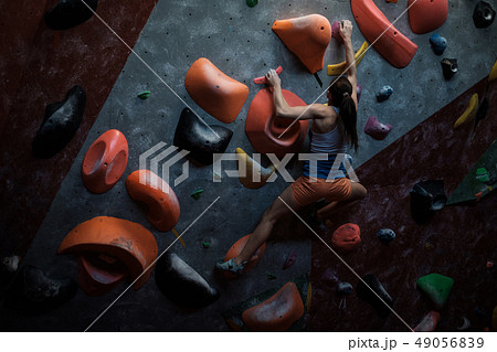 Athletic woman practicing in a bouldering gym Athletic woman practicing in a bouldering gym 49056839