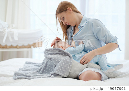 Happy middle aged mother breast feeding her baby Happy middle aged mother breast feeding her baby 49057091