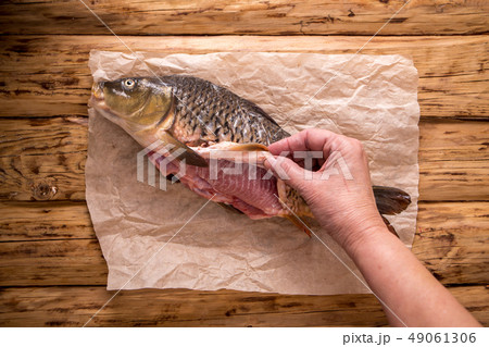 Cook removes carp skin Cook removes carp skin 49061306