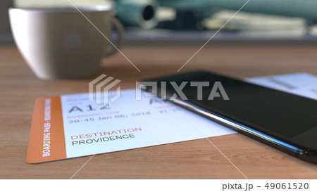 Boarding pass to Providence and smartphone on the table in airport while travelling to the United Boarding pass to Providence and smartphone on the table in airport while travelling to the United 49061520