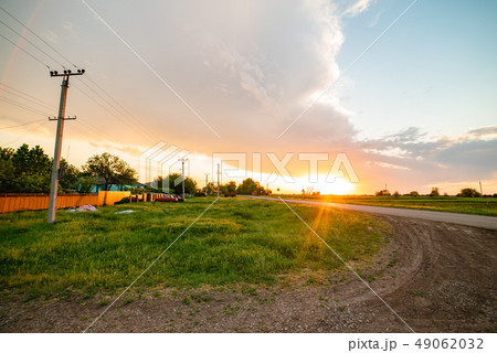 Russia village sunset spring bright sun road poles and wires 49062032