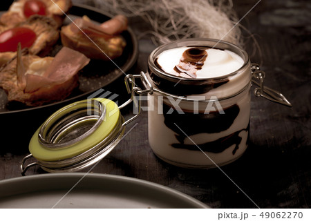 Glass jar with cover full of white and brown sauce 49062270