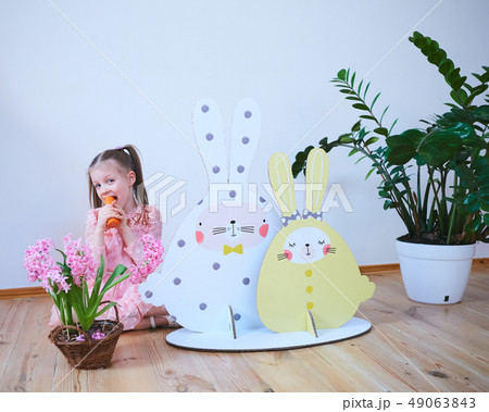 Easter 2019 Beautiful little girl in a dress with Easter decorations. Big Easter bunnies. A lot of Easter 2019 Beautiful little girl in a dress with Easter decorations. Big Easter bunnies. A lot of 49063843