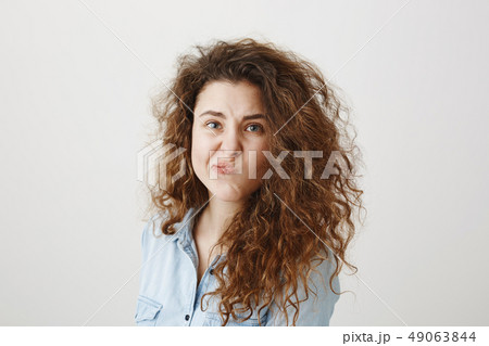 Portrait beautiful woman face close up portrait young curly hair studio on gray 49063844
