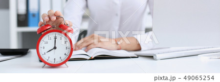 Smiling business woman holding in hand clock Smiling business woman holding in hand clock 49065254