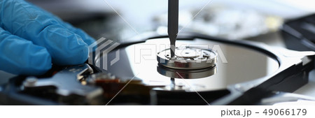 Male repairman wearing blue gloves dismantles specialized 49066179