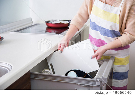 食洗機にまな板を入れる女性 食洗機にまな板を入れる女性 49066540