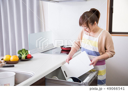 食洗機にまな板を入れる女性 49066541