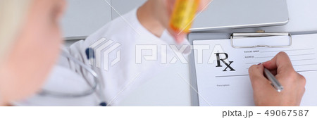 Female doctor hand hold jar of pills and write prescription Female doctor hand hold jar of pills and write prescription 49067587