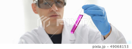 A male chemist holds test tube of glass 49068153