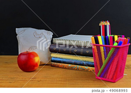 Concept of school lunch break with apple and school supplies on wooden desk, selective focus. Books 49068993