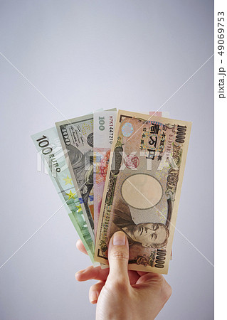 一万円札と海外紙幣を持つ女性の手 49069753