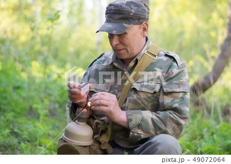 hunter in camouflage splashes the kerassene lamp 49072064