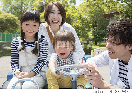 遊園地でバッテリーカーに乗る家族 49075948