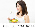 Portrait of a beautiful young Asian woman eating fresh salad fro 49076211