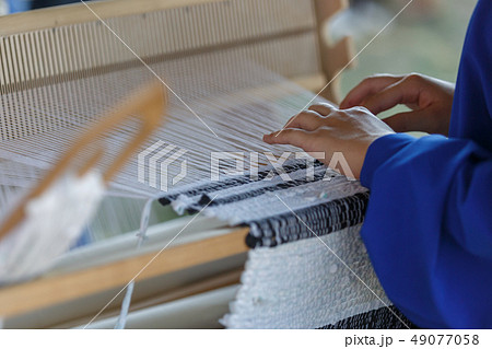 Young woman weaves a white cloth Young woman weaves a white cloth 49077058