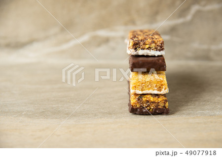 Various muesli bars on marble stone background 49077918