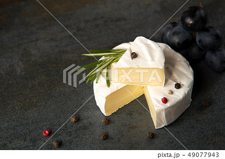 Cheese camembert or brie with dark grapes 49077943