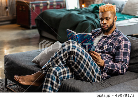 Nice thoughtful man reading an interesting book Nice thoughtful man reading an interesting book 49079173