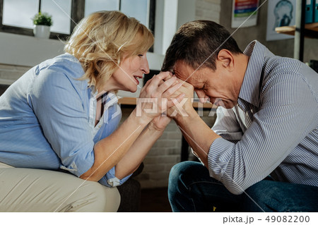 Desperate old man leaning on hand of his wife 49082200