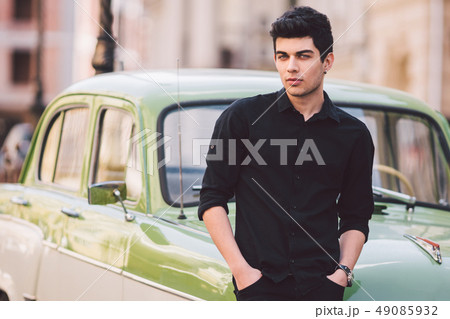 portrait, handsome, male, model, brunette Mediterranean race Turkish man stands near a retro car of portrait, handsome, male, model, brunette Mediterranean race Turkish man stands near a retro car of 49085932