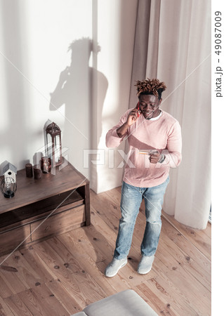Kind brunette male person looking at his card Kind brunette male person looking at his card 49087009