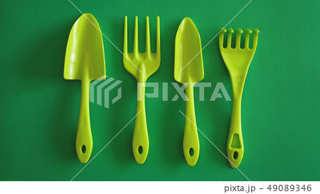Set of green garden tools on green background Set of green garden tools on green background 49089346