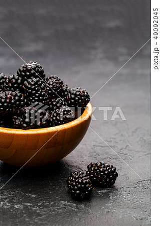 Image of blackberry in wooden cup on empty black background. Image of blackberry in wooden cup on empty black background. 49092045