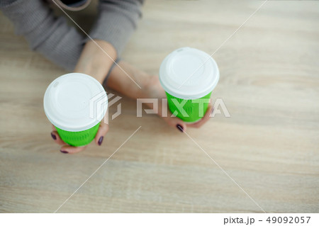 Barista in apron is holding in hands hot coffee in Barista in apron is holding in hands hot coffee in 49092057