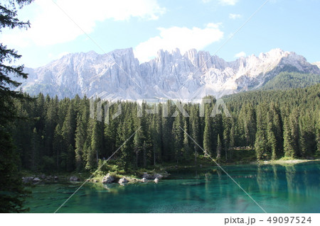カレッツァ湖とドロミティ山塊と岩と湖面の写真素材