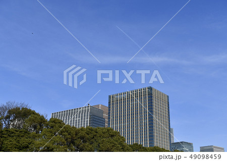 日本の東京都市景観　青空に映える飛行機雲と超高層ビルなどを望む 49098459