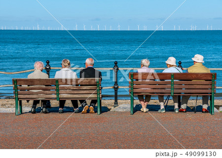People sitting watching the ocean 49099130