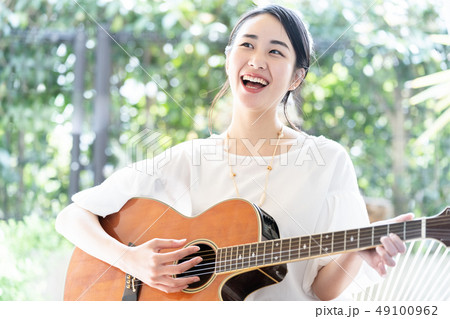 ギター 女性 楽器の写真素材