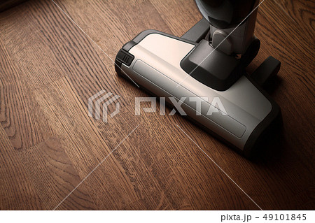 white cordless vacuum cleaner on wooden brown white cordless vacuum cleaner on wooden brown 49101845