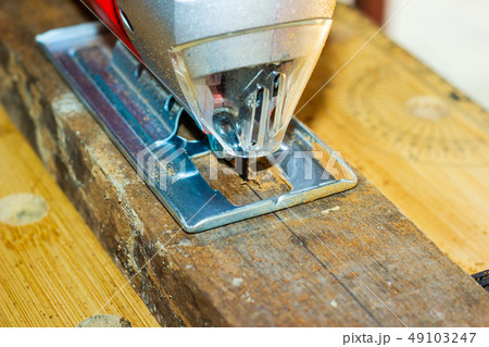 Close-up sawing electric jigsaw in the board 49103247