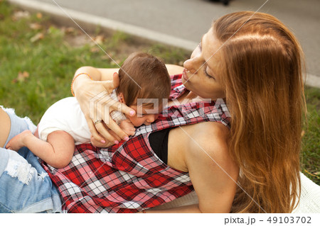 Mother holding newborn baby girl in the park 49103702