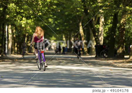 A girl biking in the Amsterdam Vondelpark 49104176