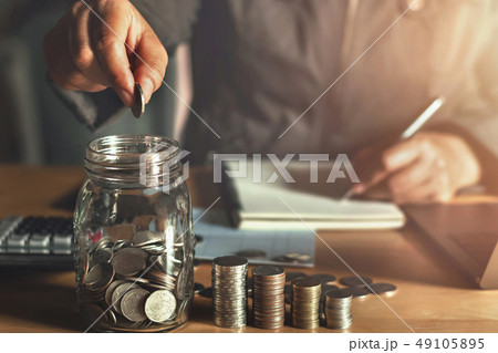 businessman holding coins putting in glass. businessman holding coins putting in glass. 49105895