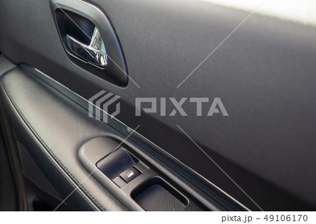 Car interior details of door handle with windows controls. Car window controls and details 49106170