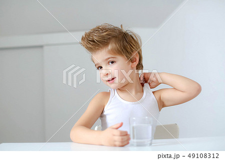 Cute smiling boy with glass of water isolated on a white background 49108312