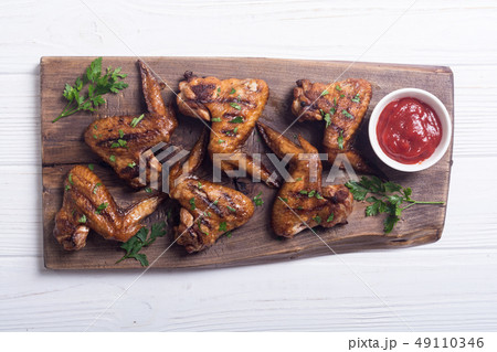 Grilled chicken wings with tomato sauce 49110346