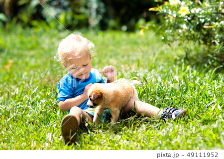 Kids play with puppy. Children and dog in garden. Kids play with puppy. Children and dog in garden. 49111952
