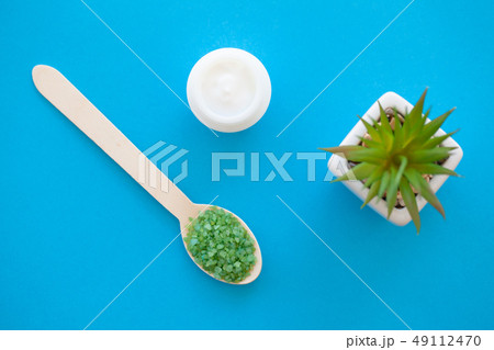 Spa. Green sea salt in wooden spoons on a white background with a space for a text. 49112470