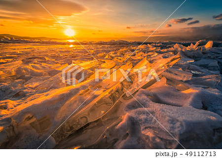 Sunset sky with natural breaking ice over frozen 49112713